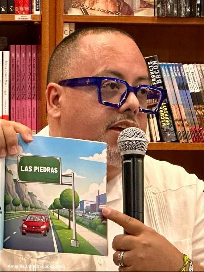 Edward Rodriguez holding up the Las Piedras illustration from the book while speaking into a microphone
