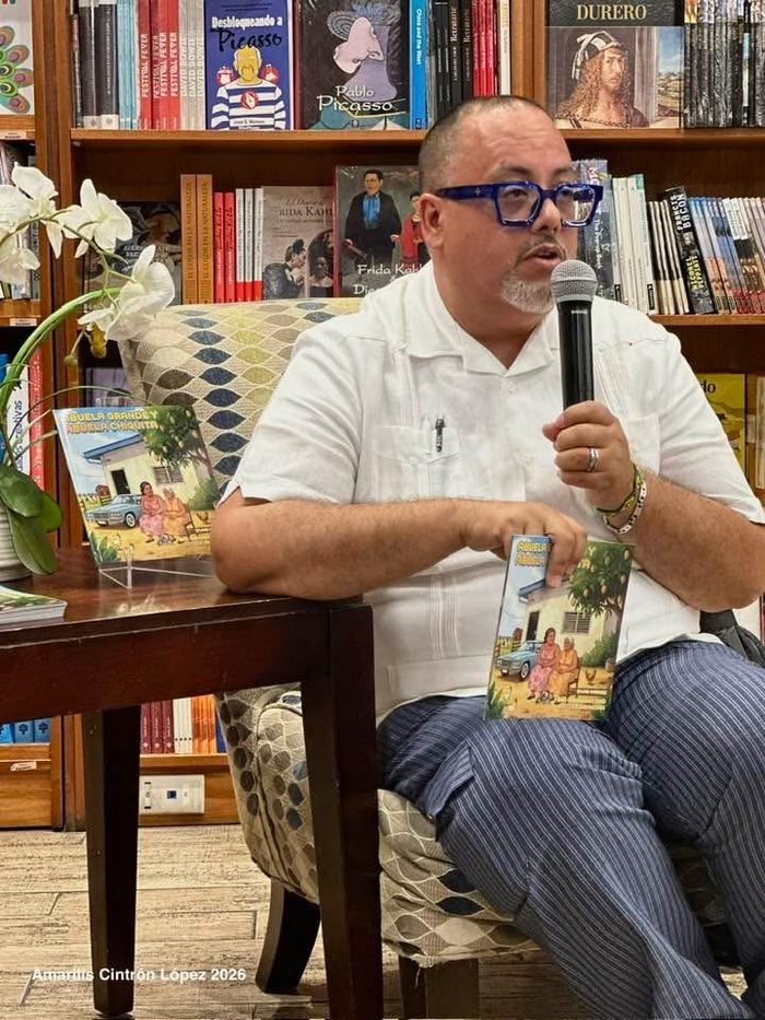 Edward Rodriguez presenting the book seated, with a second copy displayed on the table beside him