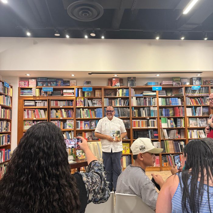 Edward Rodriguez standing and presenting while guests take photos