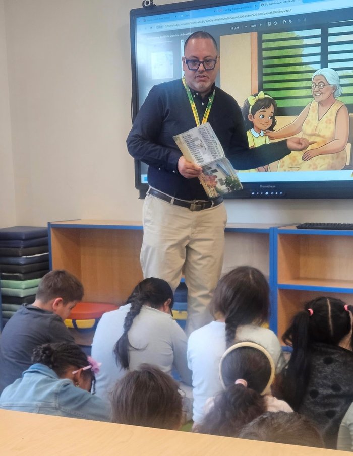Edward Rodriguez reading aloud from the book as the matching illustration displays on the classroom screen