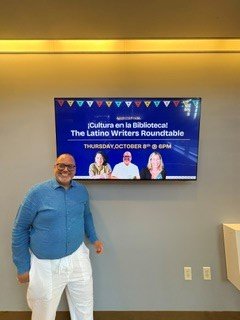 Edward Rodriguez beside the lobby screen announcing the event