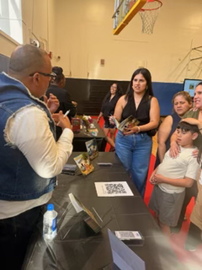 Edward Rodriguez signing books for attendees at the signing table
