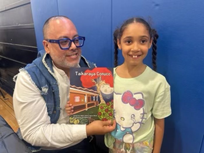 Edward Rodriguez with young author Malia holding her book Taikaraya Conuco
